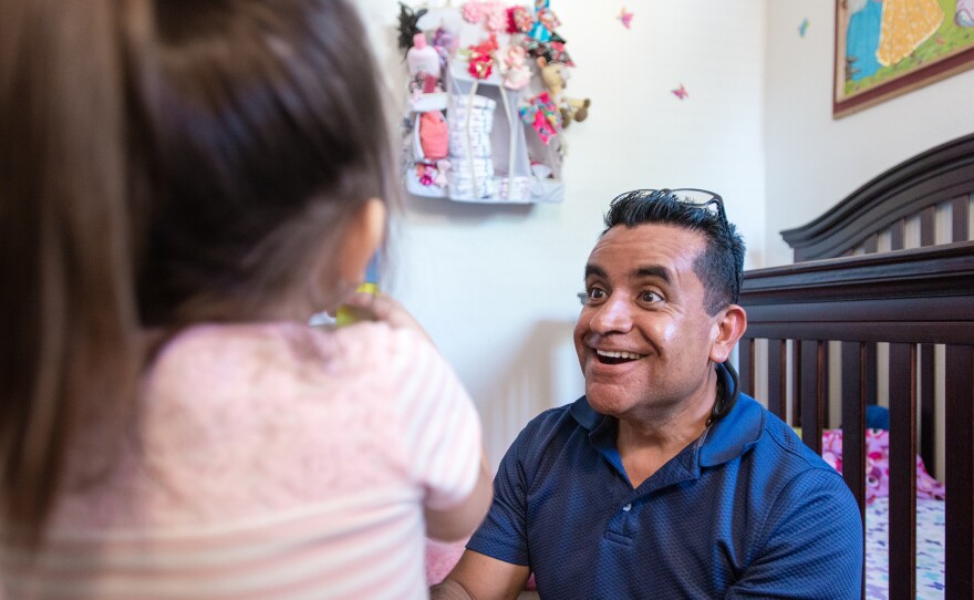 Rosendo Gil plays with 3-year-old Leilanie Lopez. He's encouraged her parents to read to her every day.