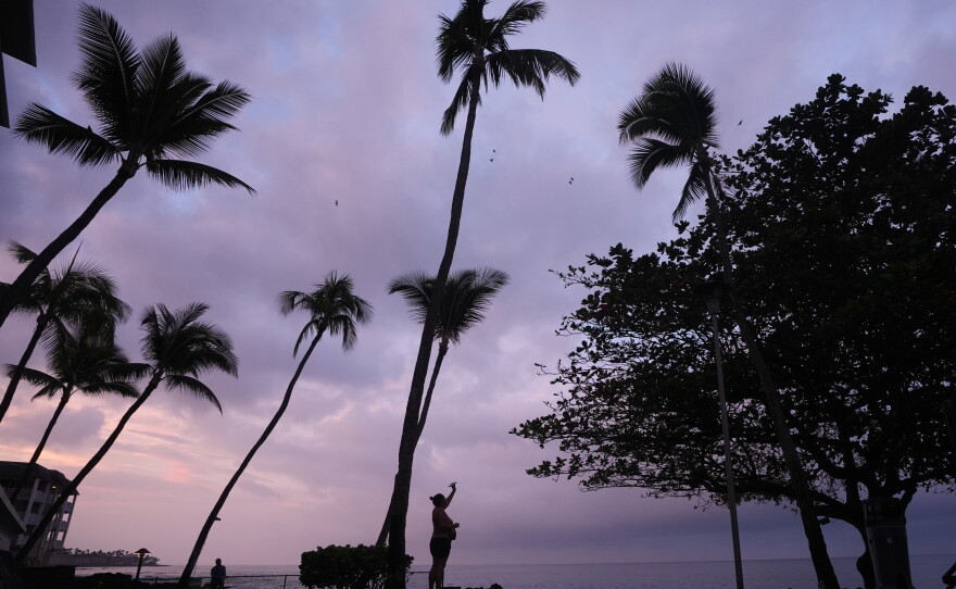 Ryanna Fry takes a picture of clouds as Hurricane Nolo sits nearby in Kona, Hawaii, Friday, Sept. 25, 2026.