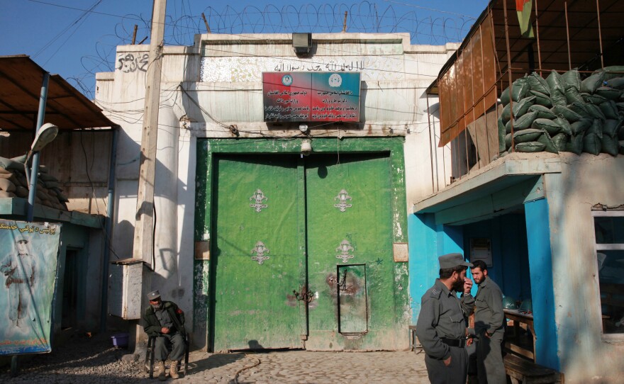 Men guard the gate of a women's prison in Afghanistan.