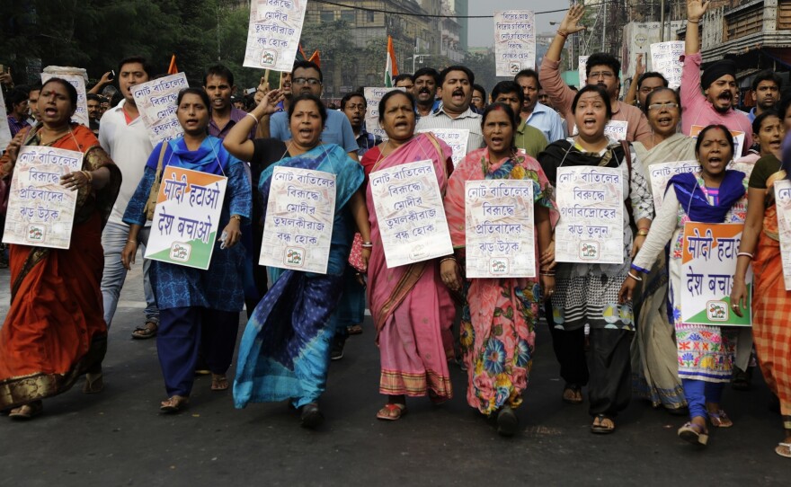 In Kolkata, protesters hold banners and shout slogans during a march against the decision to withdraw high denomination notes from circulation.