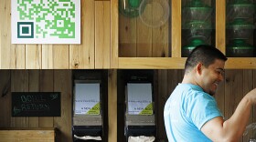 Manuel Martinez, the manager of a popular salad restaurant in Washington, D.C., called Sweetgreen, assists a customer. Martinez says customers use the QR code on the wall to learn about promotions and to get discounts.