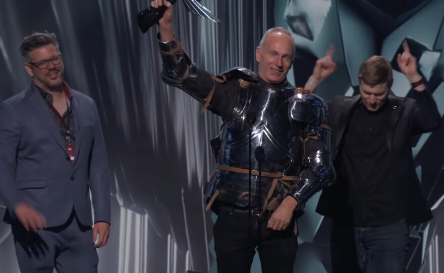 Larian Studios CEO Swen Vincke, center, celebrates Baldur's Gate 3's big win in plate armor.