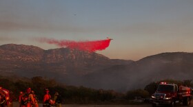 Firefighters on the ground watch as a plane drops retardant on the Wildcat fire near the Barona Casino in Lakeside, June 17, 2015.