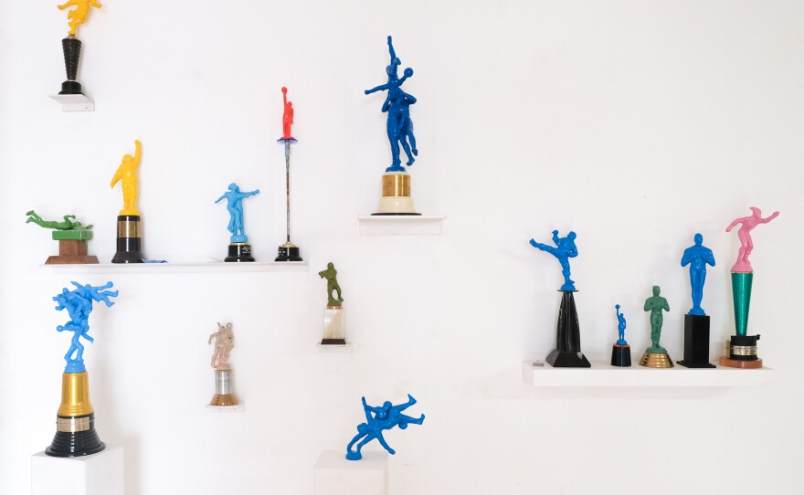 painted toy soldiers are shown installed on trophy stands and arranged on a white wall.