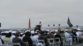 An officer talks to the crowd at the memorial service for the five Navy helicopter crew members who were killed in a crash off the coast last week. The service was held aboard the USS Midway in downtown San Diego. 