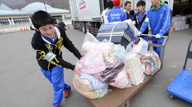 Volunteers push a trolley filled with blankets destined for displaced people in the city of Kamaishi in Iwate prefecture.