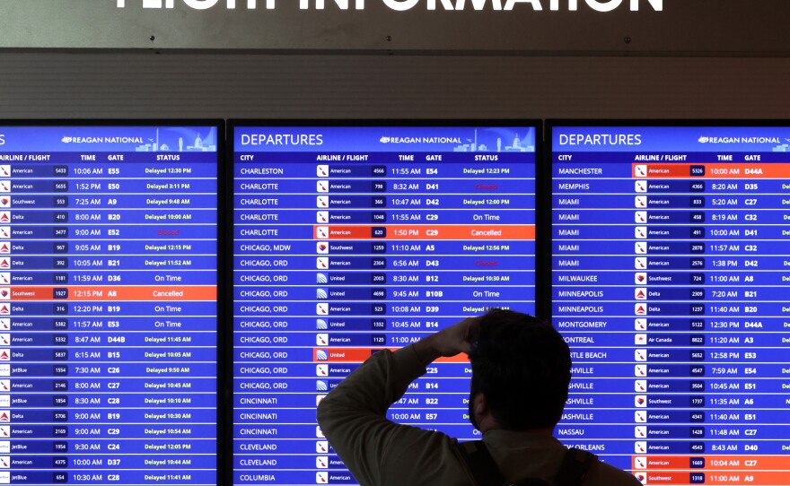 A traveler looks at a flight information board at Reagan Washington National Airport on Thursday.