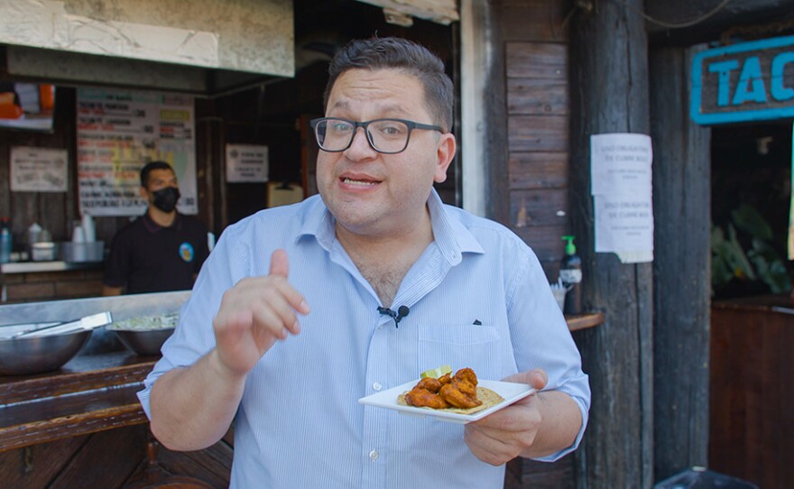 Host Jorge Meraz explains the ingredients in a taco from Taco Loco in Rosarito. Mexico.