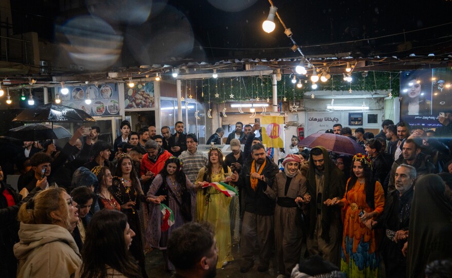 A group of people dance in the center of Akre in celebration of Nowruz.