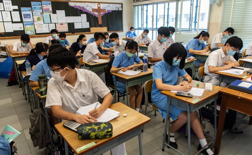 High school students wear masks inside a classroom.
