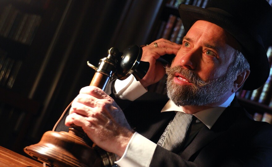 Robert Smith playing the part of JP Morgan calls in the prominent bankers of the day to help solve the financial panic of 1907.