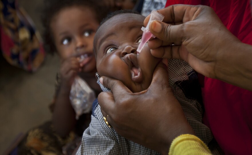 In this file photo from April 24, 2013, a Somali child receives a polio vaccine, at the Medina Maternal Child Health center in Mogadishu, Somalia.