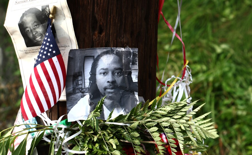 Photos of Samuel DuBose hang on a pole at a memorial, on Wednesday in Cincinnati, near where he was shot and killed by a University of Cincinnati police officer.