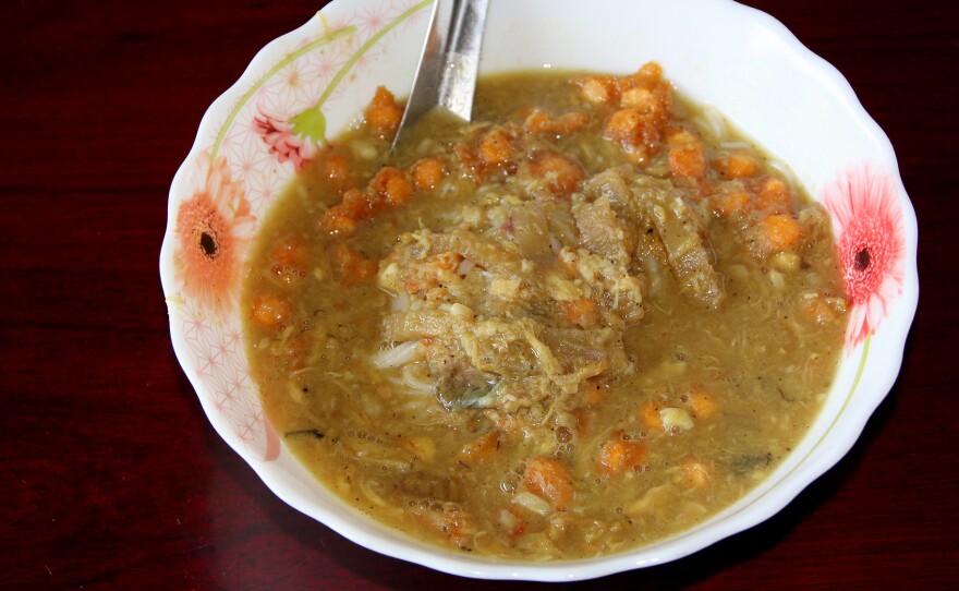 A bowl of mohinga, a flavorful fish stew with vegetables and rice vermicelli.