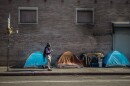 A person walks by a homeless encampment in downtown Los Angeles on Nov. 18, 2022.