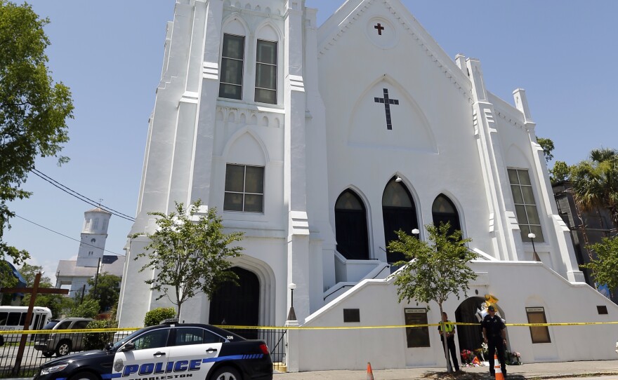 Police officers stand in front of the Emanuel AME Church in Charleston, S.C. Jurors on Thursday saw horrific photos of the church basement at the trial of Dylann Roof, accused of hate crimes in the killings of nine black people at the church last year.