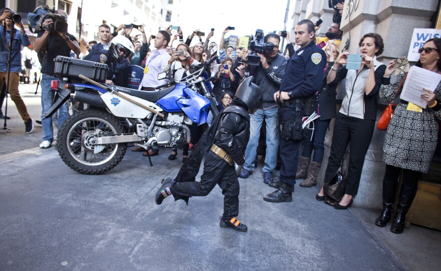 Batkid runs into a former bank vault to arrest The Riddler.