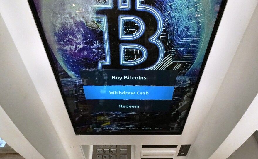 Bitcoin logo appears on the display screen of a cryptocurrency ATM at the Smoker's Choice store in Salem, N.H. (AP Photo/Charles Krupa, File)