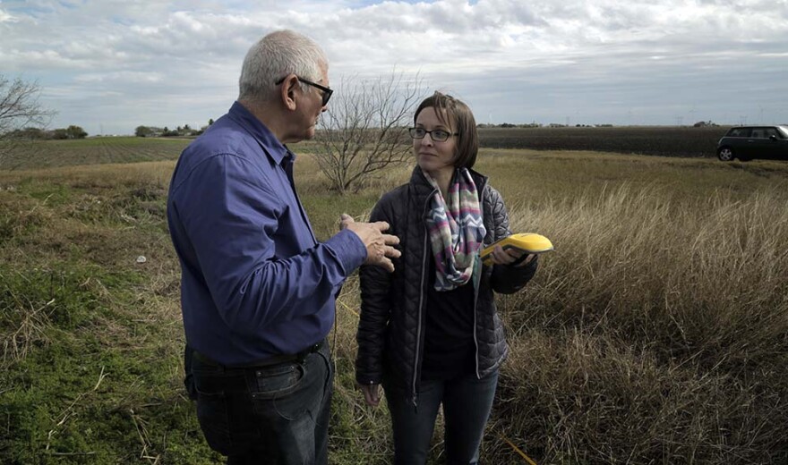 Eddie Canales and Dr. Kate Spradley survey a roadside cemetery in South Texas where many unidentified migrants are buried.