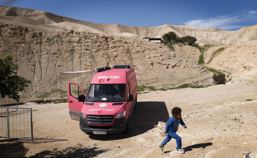 A Bedouin boy passes a mobile medical clinic run by the British charity Medical Aid for Palestinians.