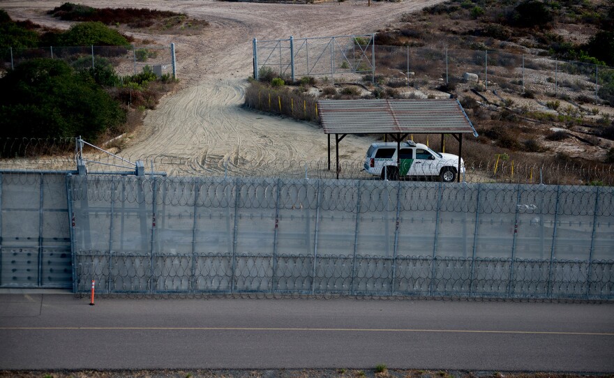 A Border Patrol agent vehicle sits between secondary fencing, which includes concertina wire at the top and bottom, and a basic chain-link fence, known as tertiary fencing. Photo was taken on Aug. 16, 2017