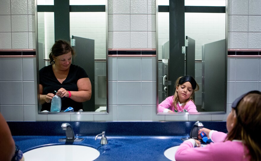 Pam Cross (left) watches her daughter, Healey, 8, as they brush their teeth in the museum bathroom before bedtime.