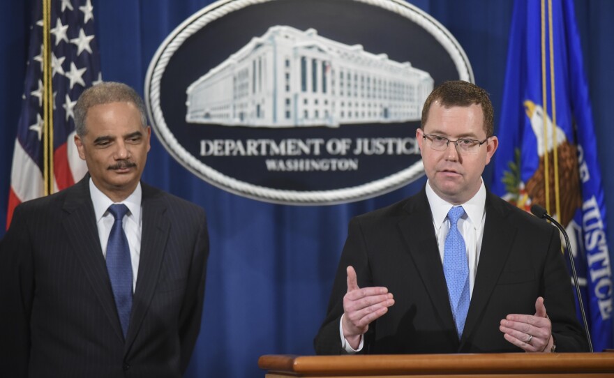 Then-acting Assistant Attorney General Stuart Delery (right) speaks at a news conference with Attorney General Eric Holder at the Department of Justice in 2015.