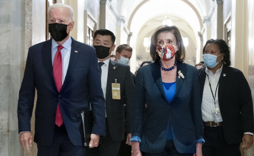 President Biden walks with House Speaker Nancy Pelosi, D-Calif., as he arrives Friday for a meeting with House Democrats to discuss their spending agenda.