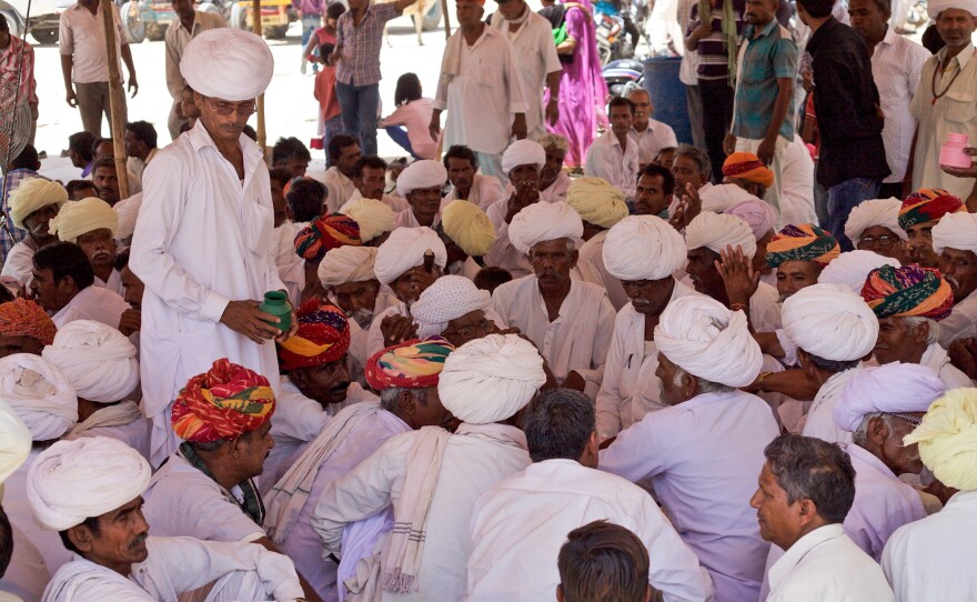 Lumbaram, standing on the left, attends to panches, or village elders, at a memorial service for his father. He will need the elders' permission to break Durga's marriage.