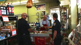 San Diego police officers Dionisio Medina and Nick Tamagni say hello to Hani Ilaian, the owner of Mid-East Market on El Cajon Boulevard.