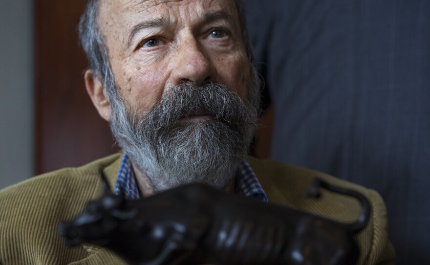 Arturo Di Modica holds a model of his Charging Bull during a news conference Wednesday.