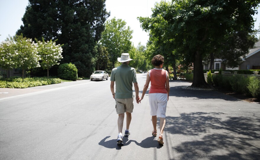 Robin and Anne Jones take a walk near their home. They say that an Alzheimer's biomarker test made it easier to plan for the future.