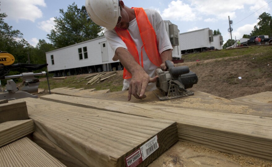 On May 9, Anthony Massie of Lexington, Tenn., works to install trailers brought in by FEMA for tornado victims in Phil Campbell, Ala.