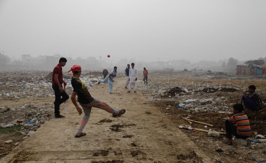 Youths play cricket in a trash field near where Zainab's body was found on Jan. 9.