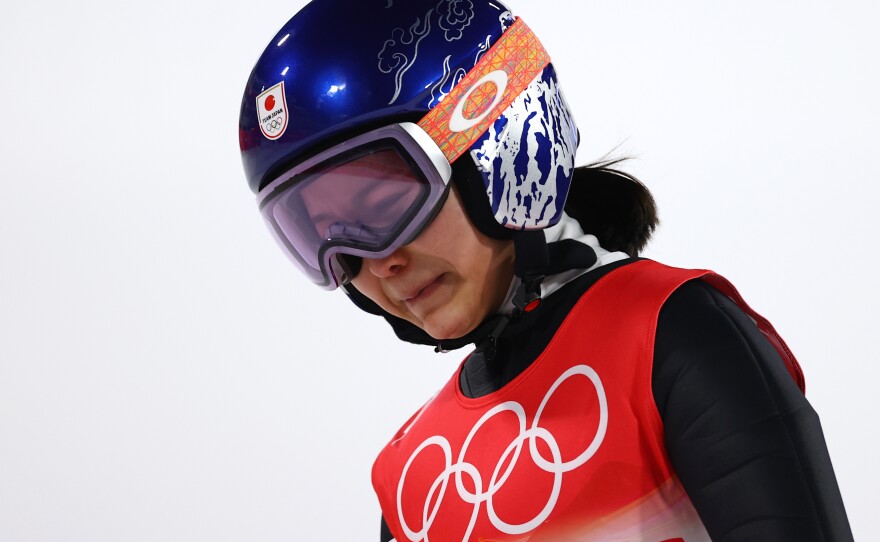 Sara Takanashi of Team Japan shows dejection after being disqualified after jumping in the final round of the mixed team ski jumping event at the National Ski Jumping Center in Zhangjiakou, China.