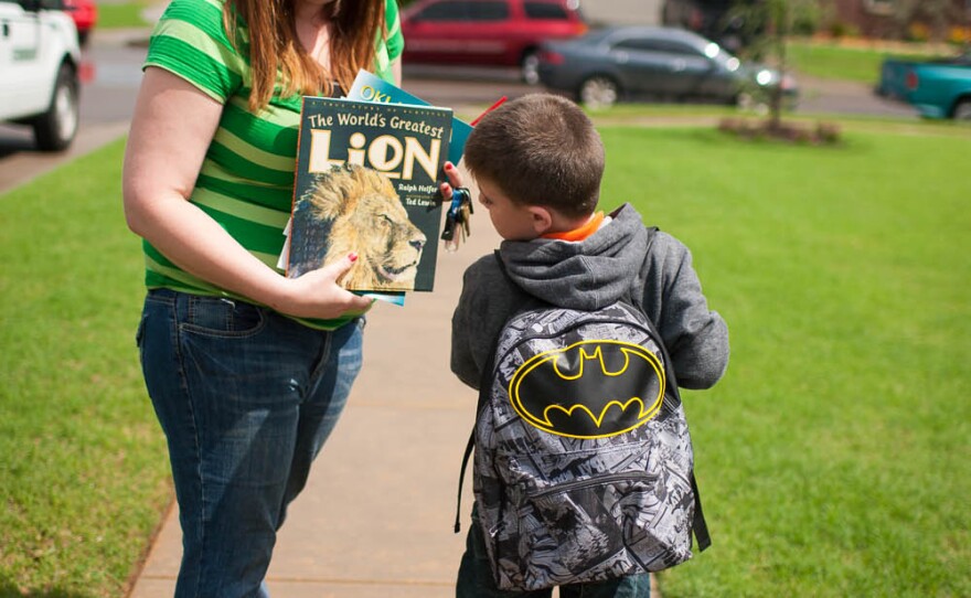 Amber Hill leaves Eastlake Elementary School with her son Jaren May. Jaren was in the autism program at Plaza Towers and went through the tornado with his teacher and fellow students at the school. Jaren came out Thursday carrying a balloon, a goody bag and a brand new backpack to replace the one he lost in Monday's tornado.