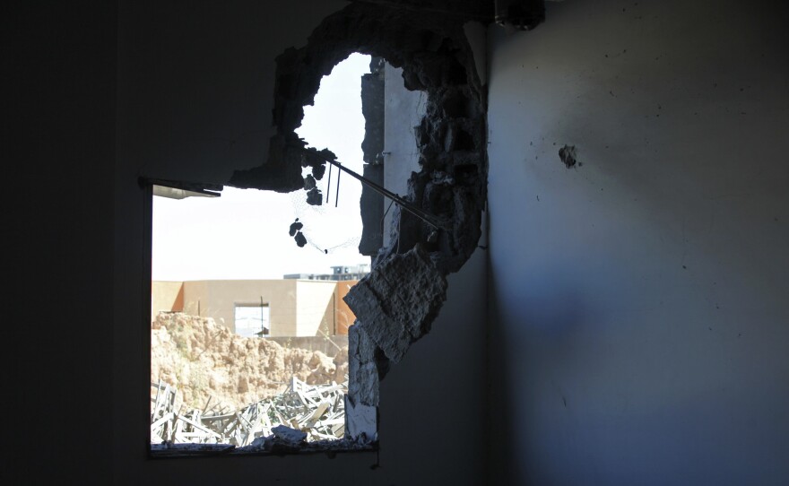 A damaged building and debris outside are seen Sunday after heavy fighting broke out between rival militias near the airport in the Libyan capital, Tripoli.