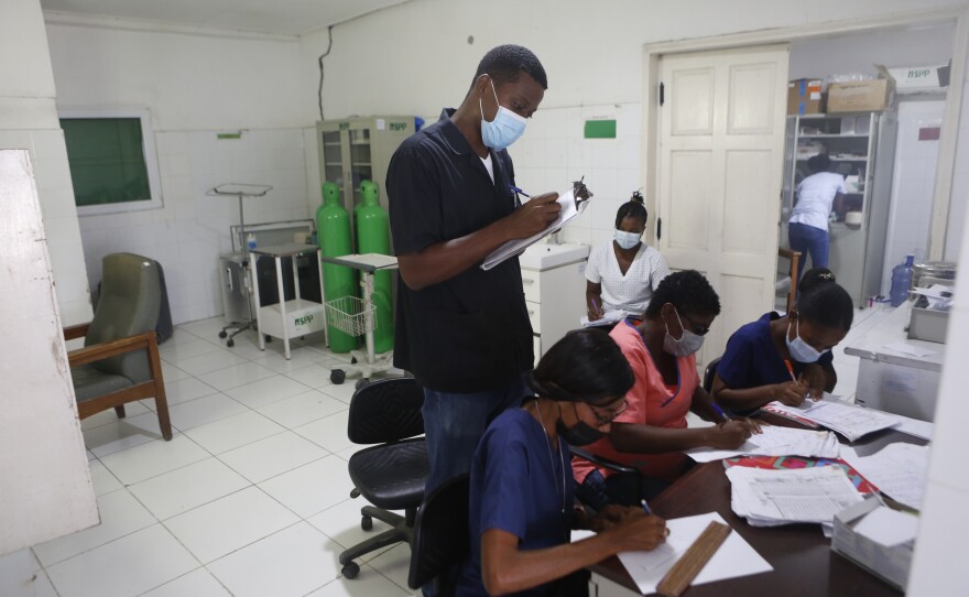 Titus talks with his staff at Immaculée Conception Hospital.