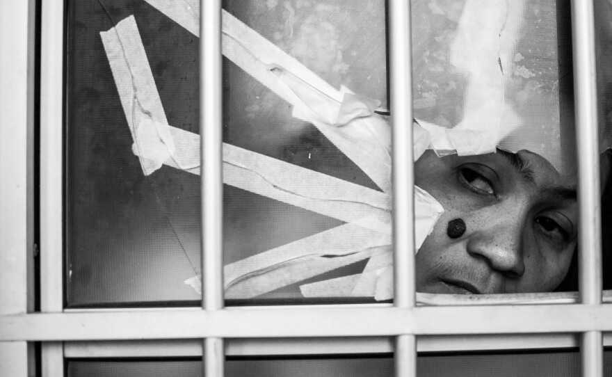 Lucia Cabral peers through a bullet hole in her door in the Alemao favela complex. Like people everywhere, she checks her phone soon after she wakes up in the morning. In these favelas, she says, it's a matter of life or death.