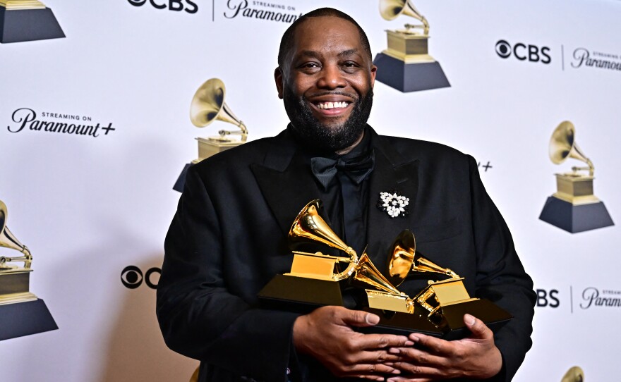 Killer Mike poses in the press room with the Grammys for best rap performance, best rap album and best rap song during the 66th annual Grammy Awards.