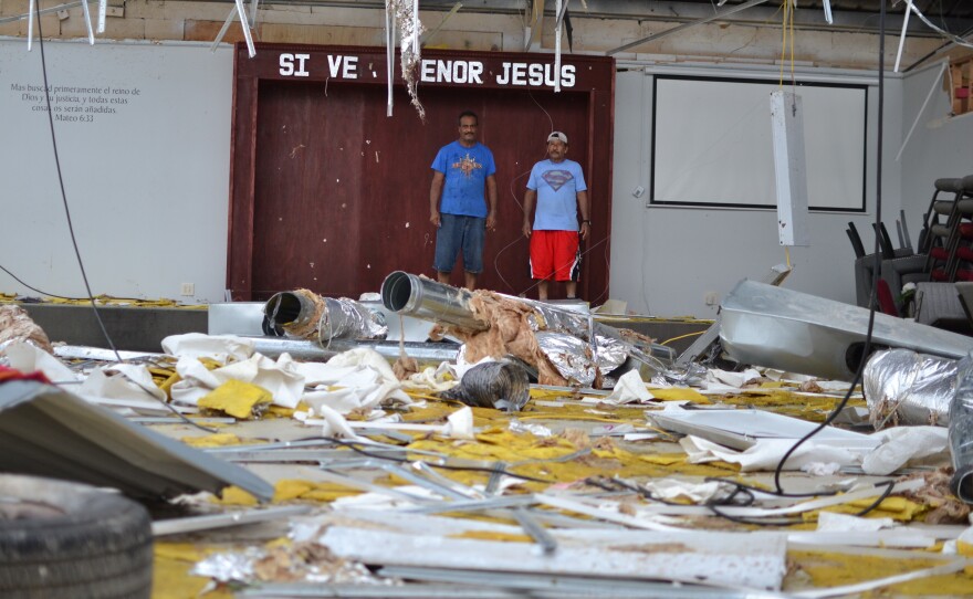 Pastor Pedro Rivera and congregation member Juan Ortega take stock of the damage at Iglesia Pentecostal Providencia Divina two days after Hurricane Ida hit Louisiana. It is a total loss.