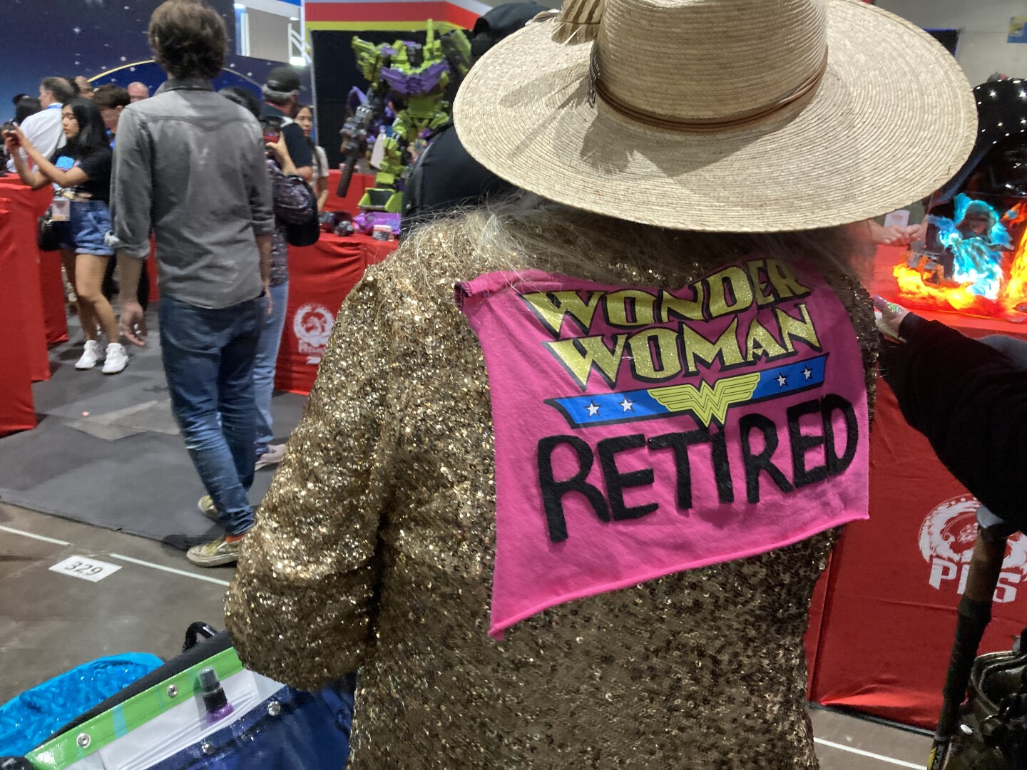 This Comic-Con attendee added a playful twist to the superhero genre with a sequined gold jacket and a sign that read "Wonder Woman Retired" on July 26, 2025.