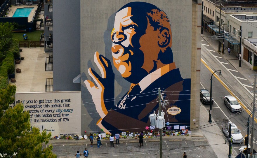 Mourners pay their respects at a mural of Rep. John Lewis painted on a building in Atlanta. The civil rights icon and congressman died on Friday.
