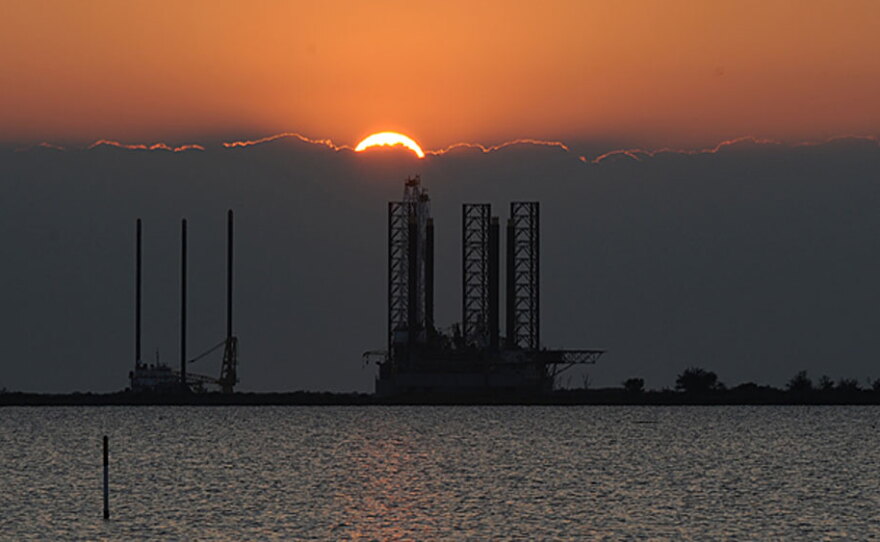The sun sets over an oil platform waiting to be towed out into the Gulf of Mexico at Port Fourchon in Louisiana.