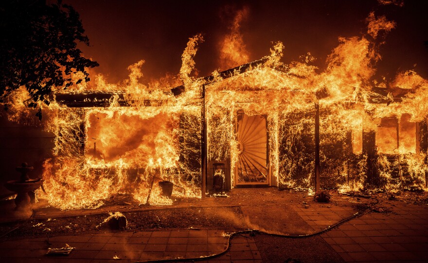 Flames consume a home on Triangle Road as the Oak Fire burns in Mariposa County, Calif., on Saturday.