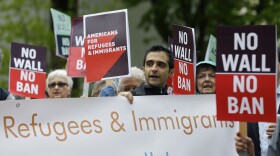 Protesters hold signs during a demonstration against President Donald Trump's revised travel ban, Monday, May 15, 2017, outside a federal courthouse in Seattle.