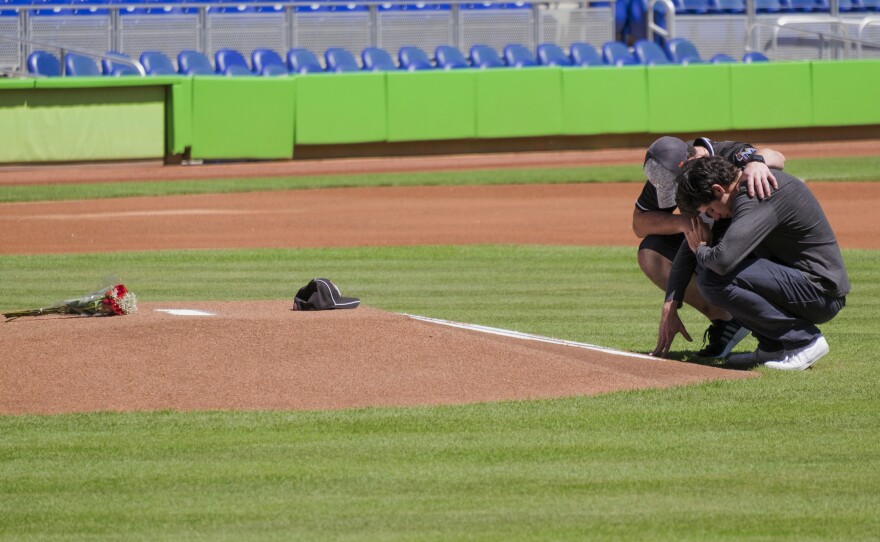 Miami Marlins player Christian Yelich (right) and teammate Justin Bour in front of a memorial for Marlins pitcher José Fernández on Sunday.