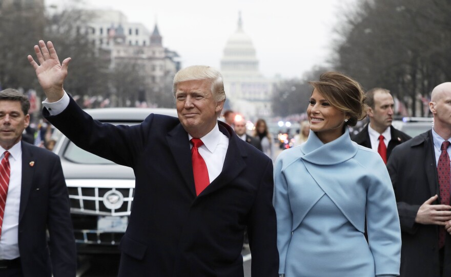 President Trump waves as he walks with first lady Melania Trump during the inauguration parade on Pennsylvania Avenue on Friday.