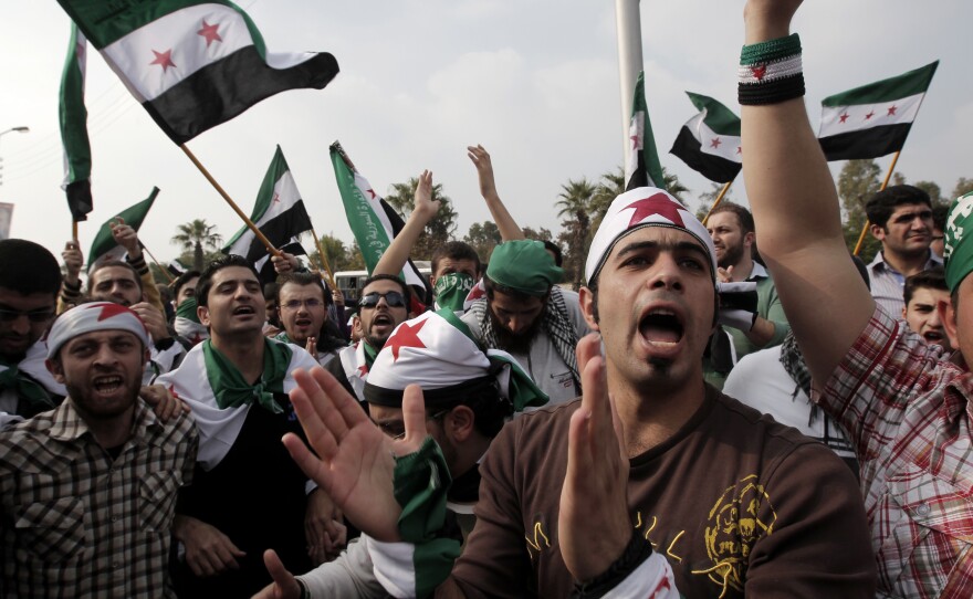 Pro-reform supporters, waving Syria's pre-Baath old national flag, protest outside the Arab League headquarters in the Egyptian capital Cairo, where a ministerial meeting on Syria was held on Nov. 24, 2011. The Arab Spring protests of that year drew many activists, advocates and journalists to the region.