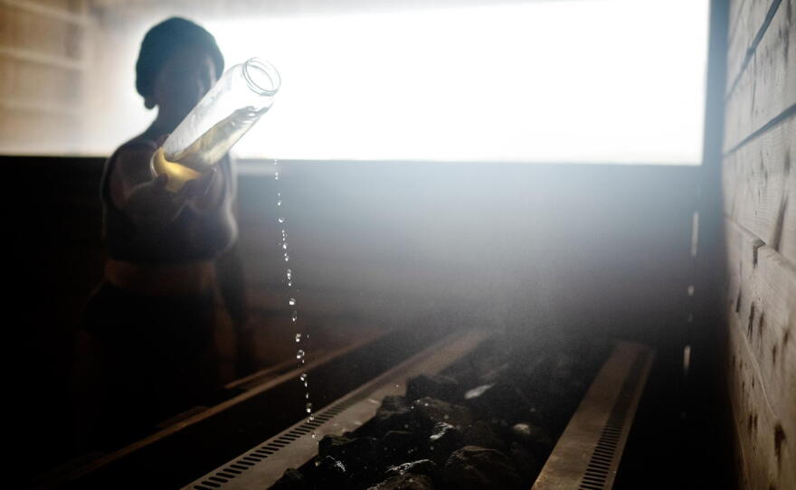 Sauna master Hilde Karlsen pours liquid on hot rocks during a sauna ritual at Sukkerbiten in Oslo, Norway, Sept. 25, 2026.